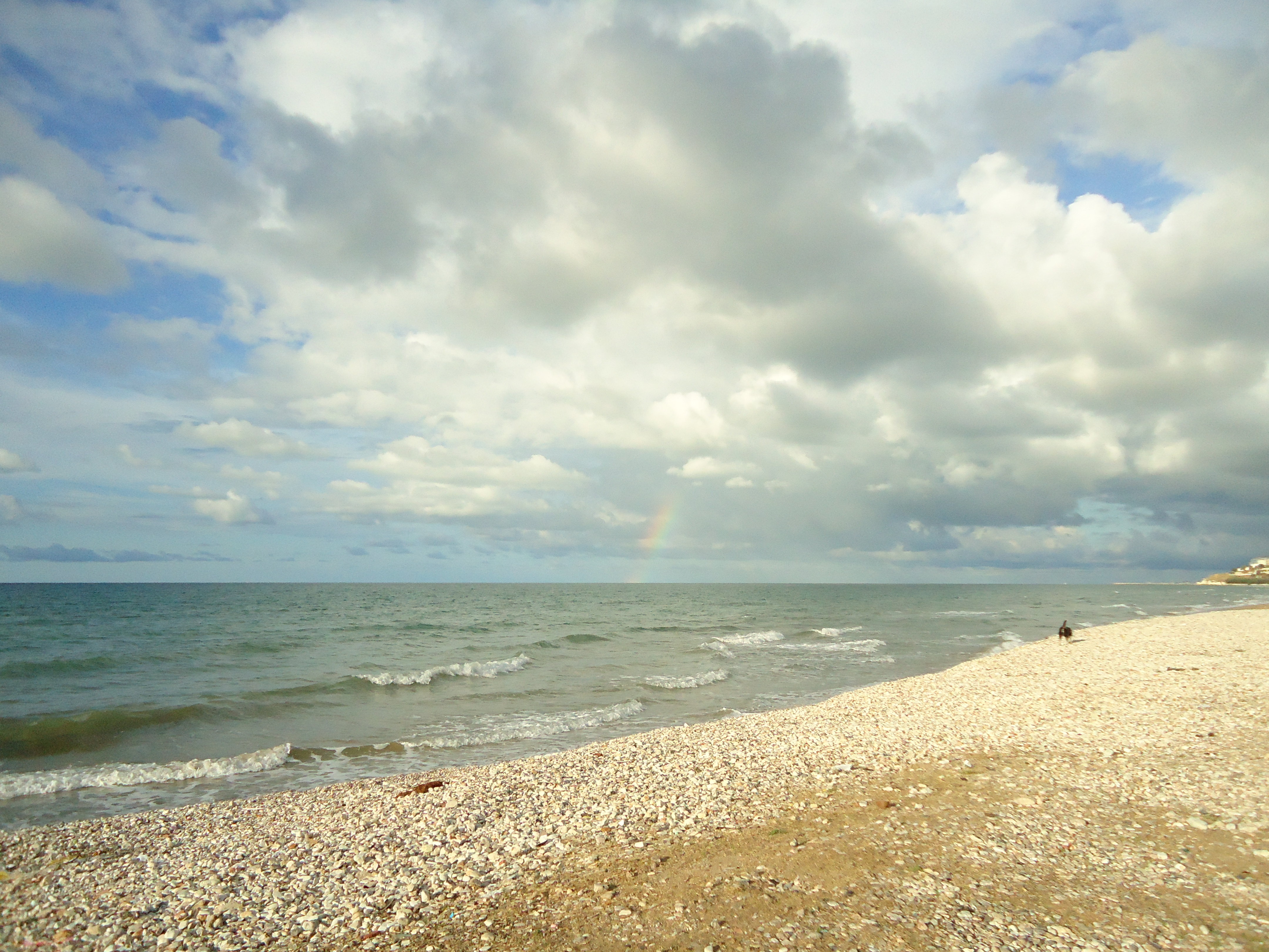 Klitzekleiner Regenbogen in Wolken versteckt